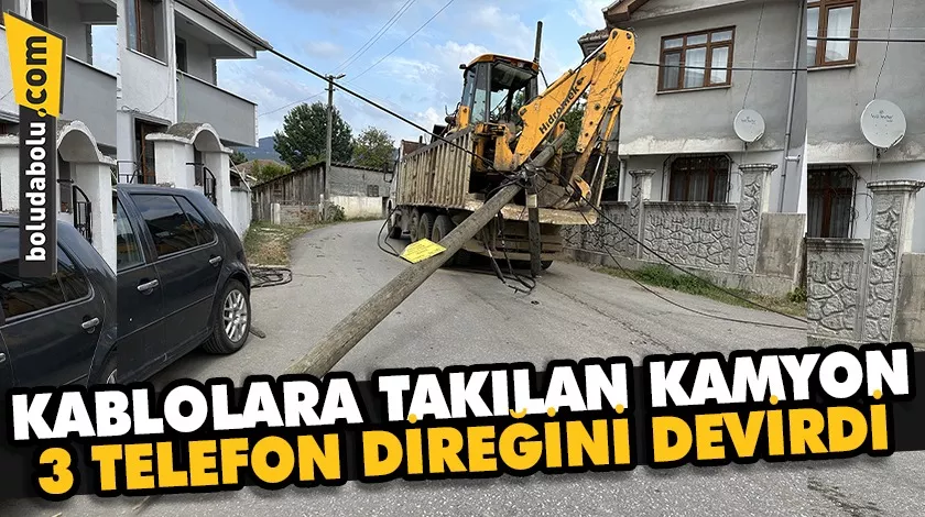 Kasasındaki iş makinesi kablolara takılan kamyon 3 telefon direğini devirdi Kasasındaki iş makinesi kablolara takılan kamyon 3 telefon direğini devirdi